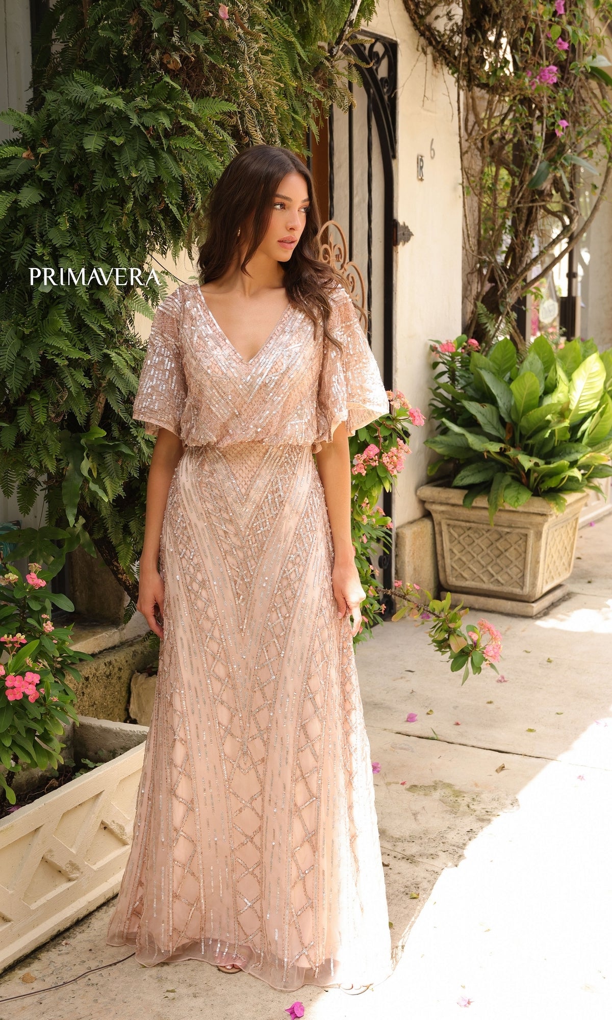 A woman wearing the Primavera 13119 Sleeved Long Sequin Formal Dress.